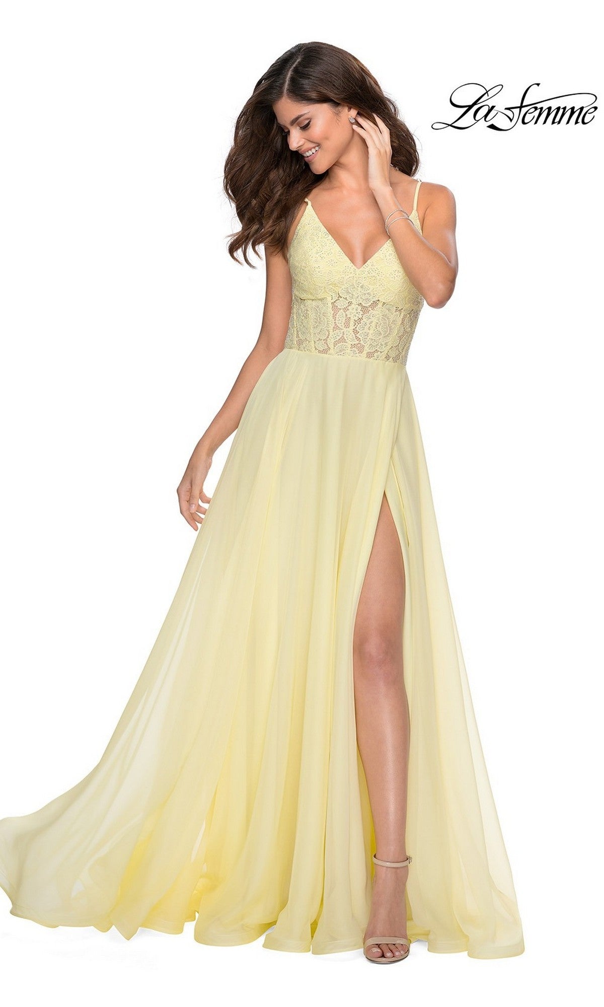 Woman wearing the La Femme Sheer-Lace-Bodice Long Prom Dress 28664 in light yellow with spaghetti straps and a high slit, posing against a white background.